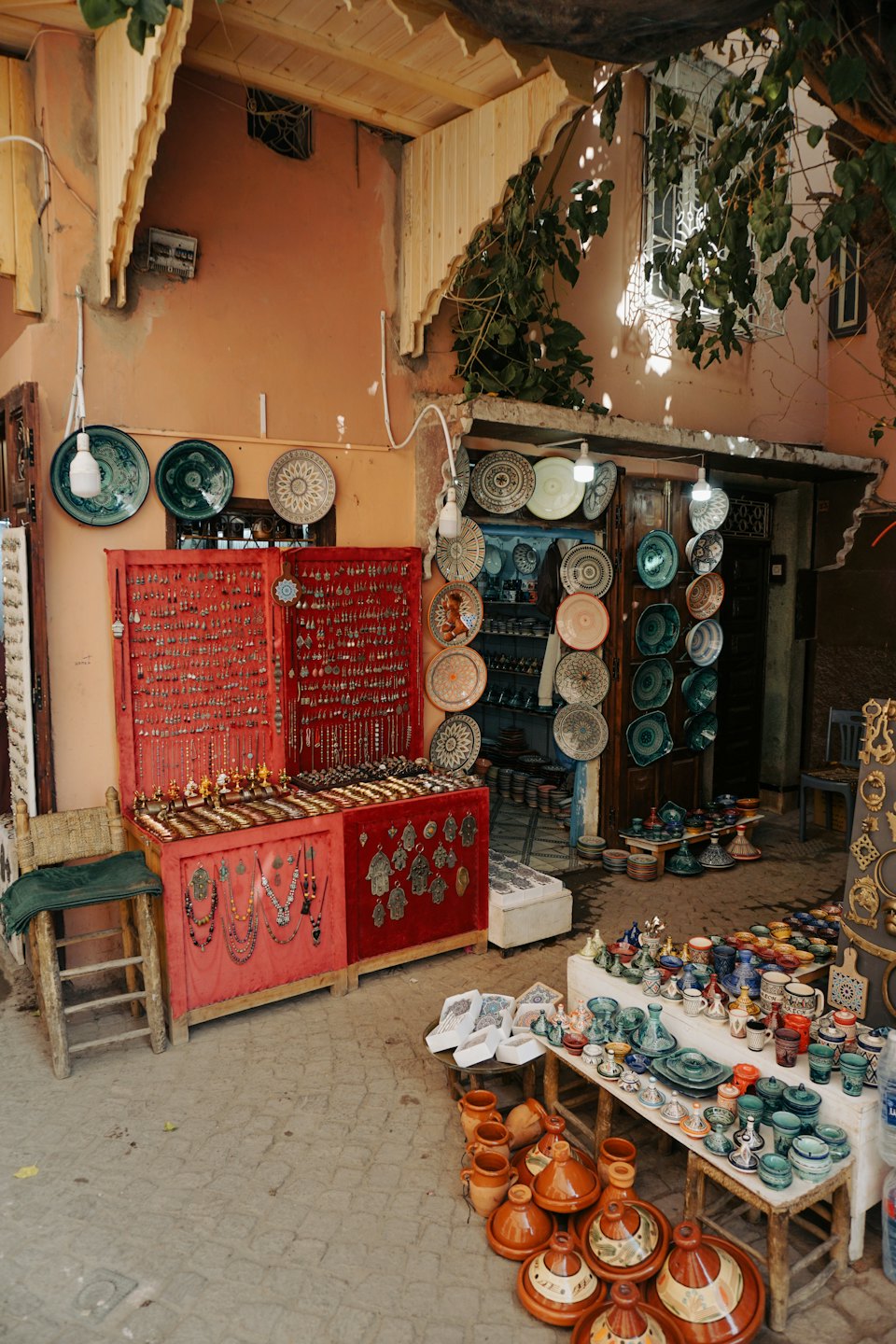 Marktstand im Freien mit Silberschmuck und bunten Keramiken.